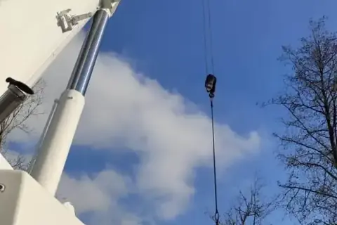 Autokran bei einer Baumfällung neben der Bundesstraße