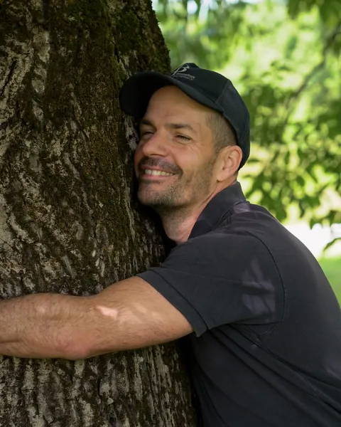 Franz Grassmann umarmt einen alten Baum